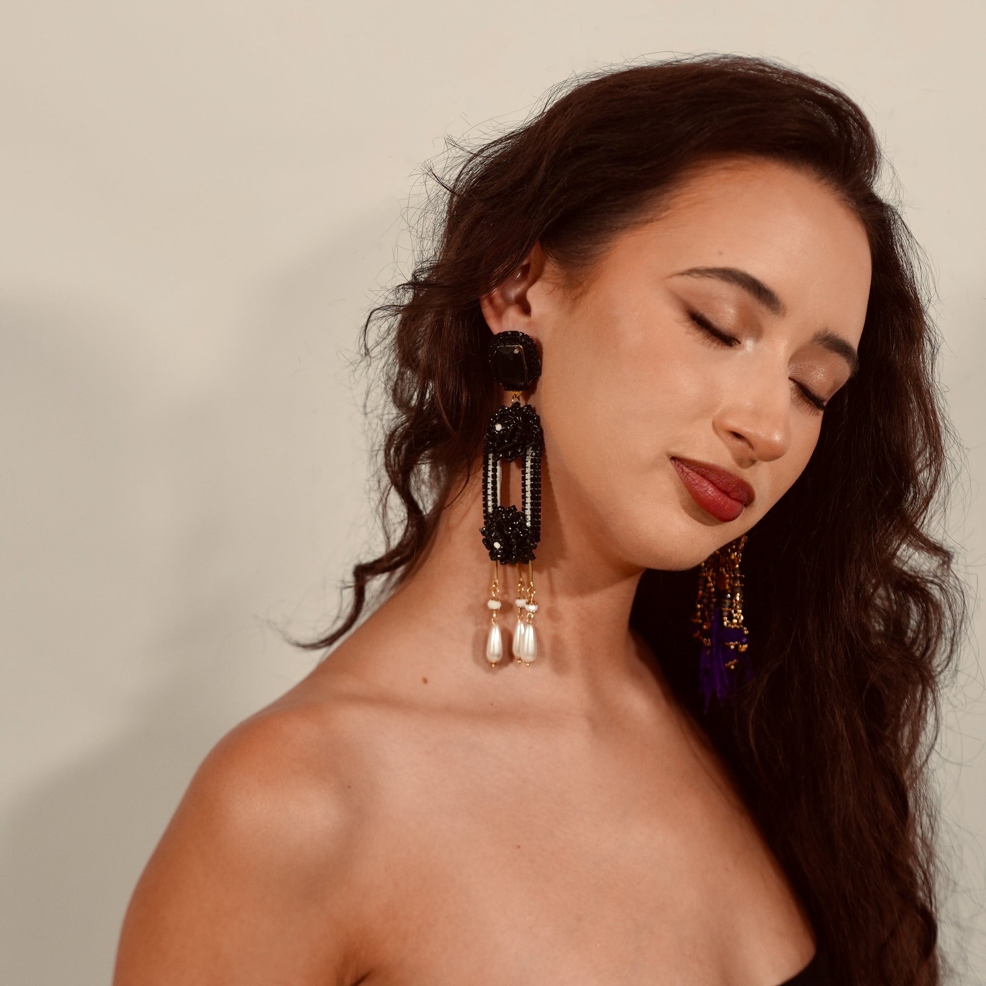 Woman wearing large hoop earrings against a neutral background