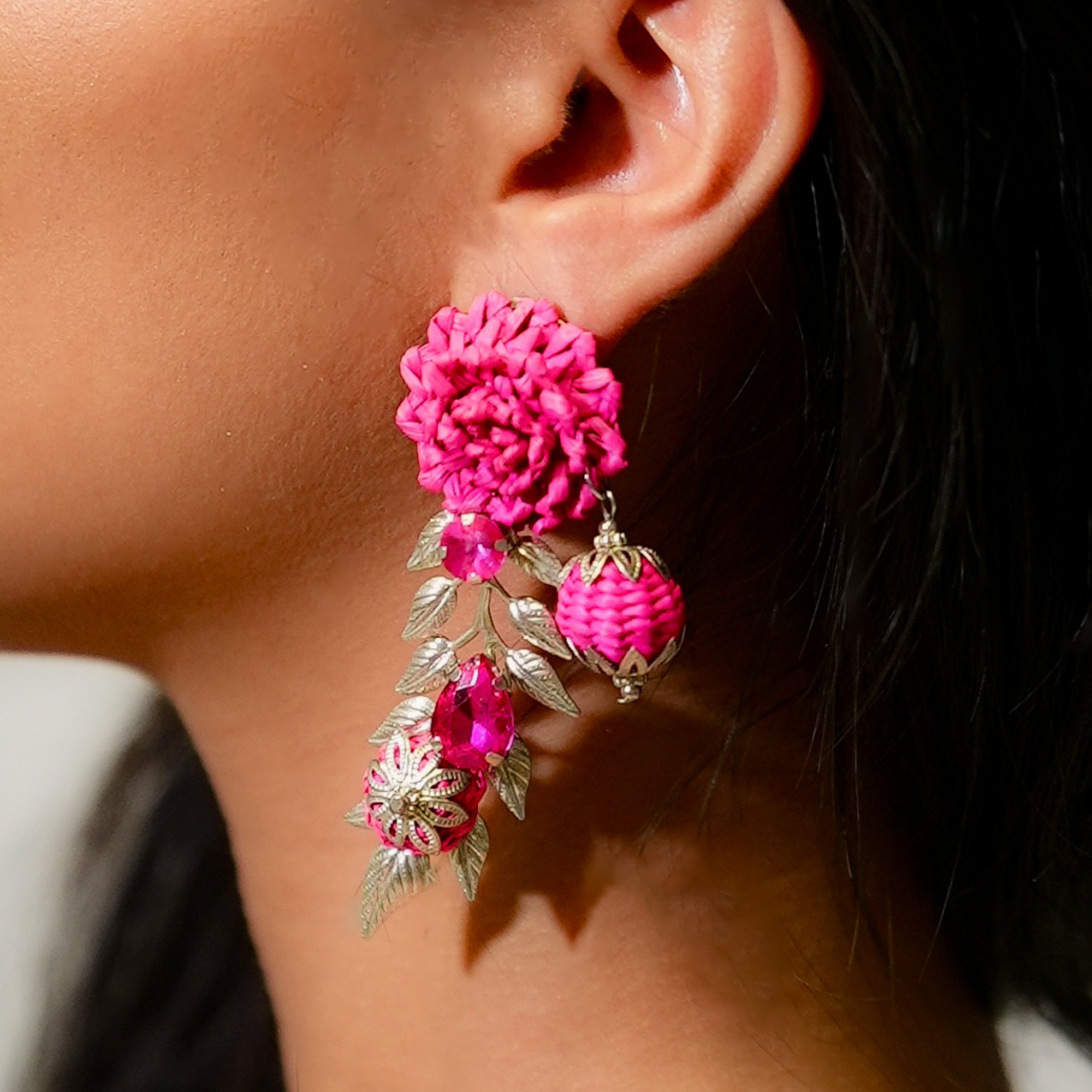 Close-up of a person wearing an ornate gold and pearl earring.