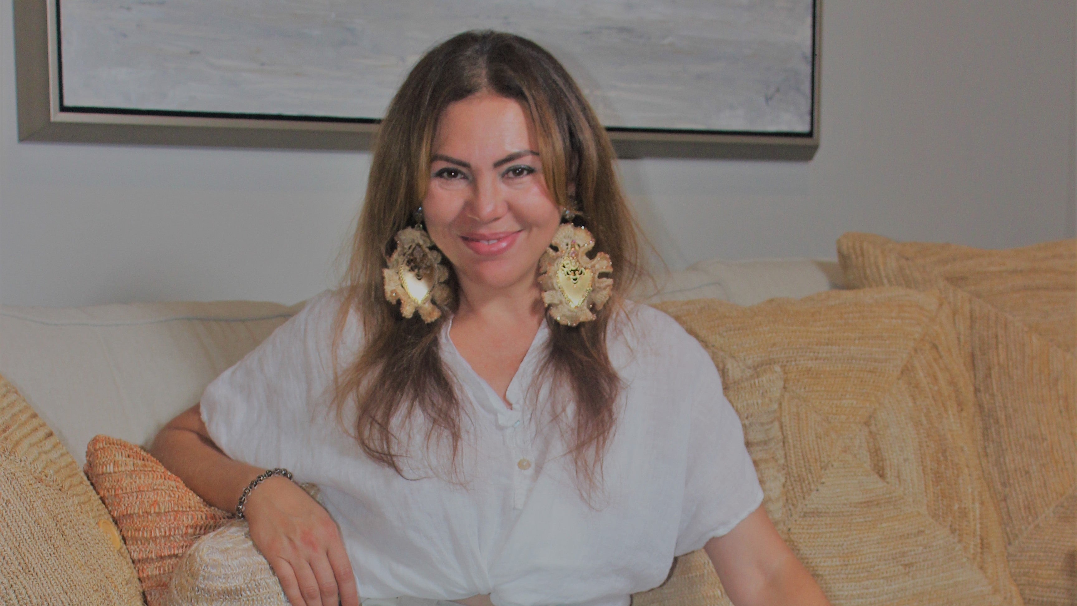 Yamary Avila sitting on a couch with a neutral background