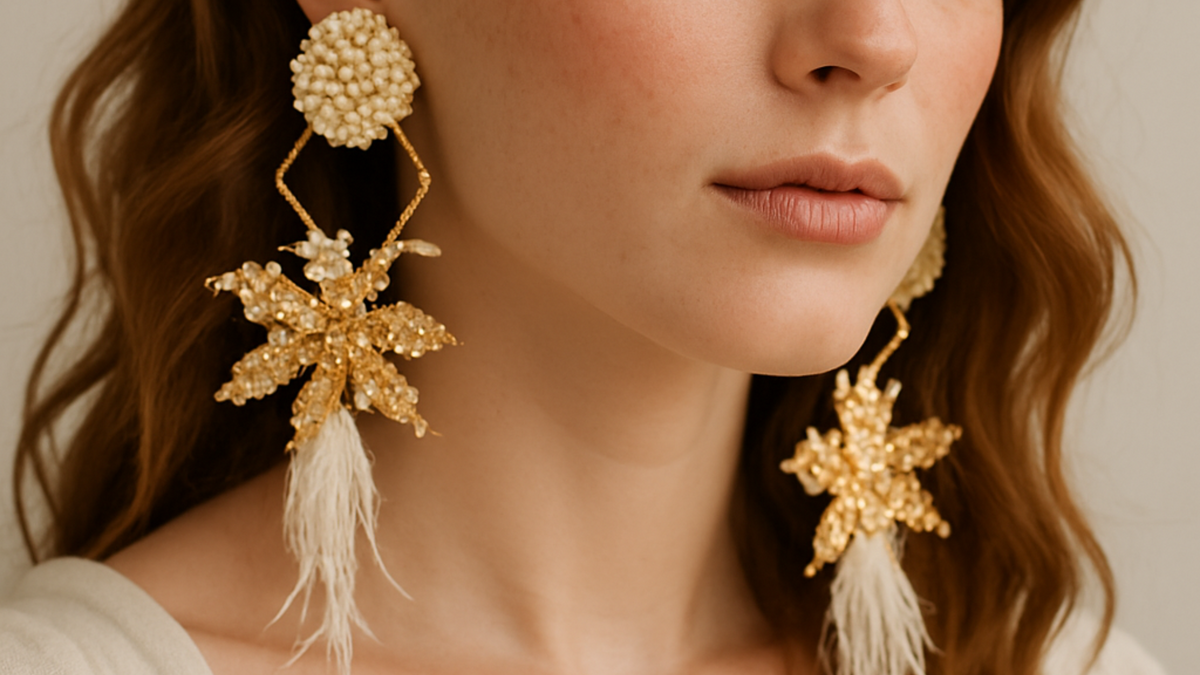 Close-up of a woman wearing handcrafted gold and pearl floral earrings with faux feather details, showcasing elegant sustainable jewelry.
