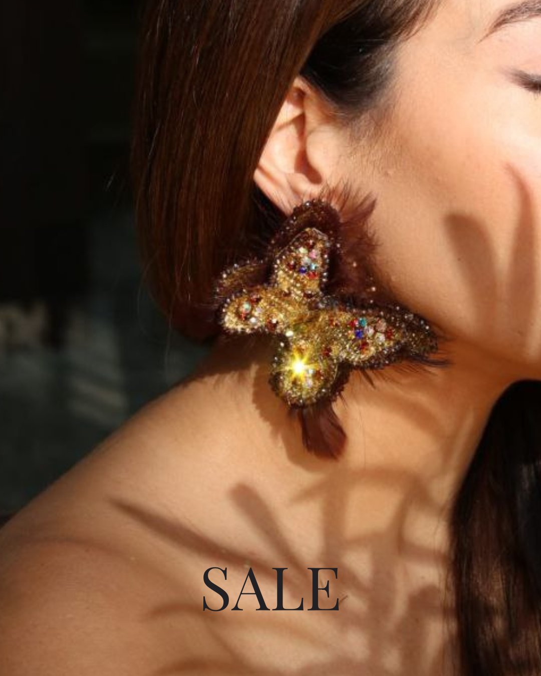 Woman wearing artisan butterfly-shaped statement earring with gold and multicolor beads — SALE up to 40% off at Yama by His Grace