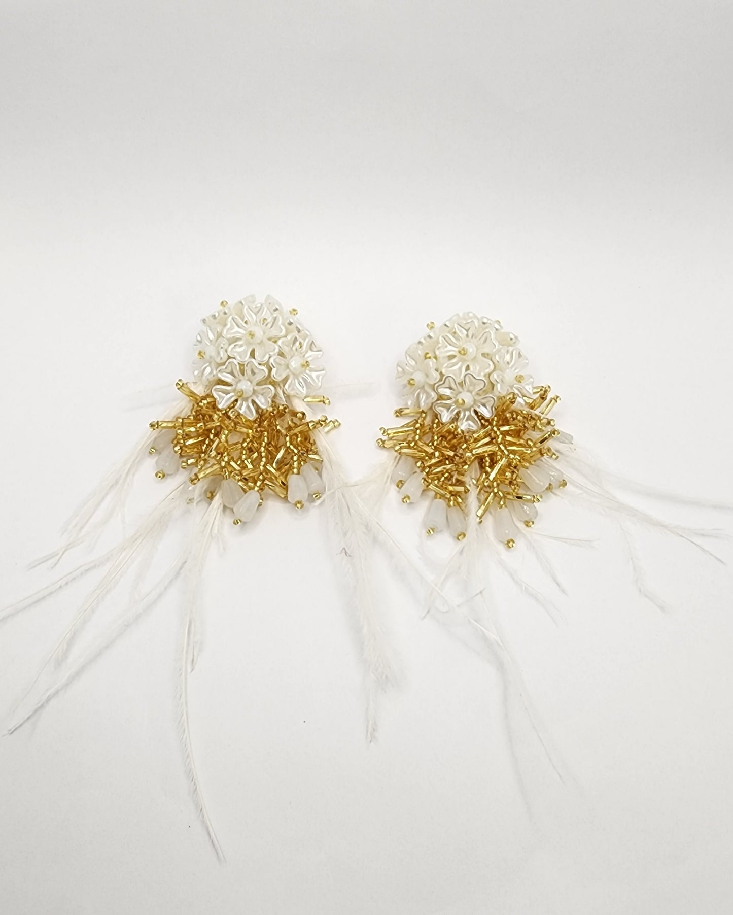 Bridal earrings with white beading, gold accents, and delicate feather details.