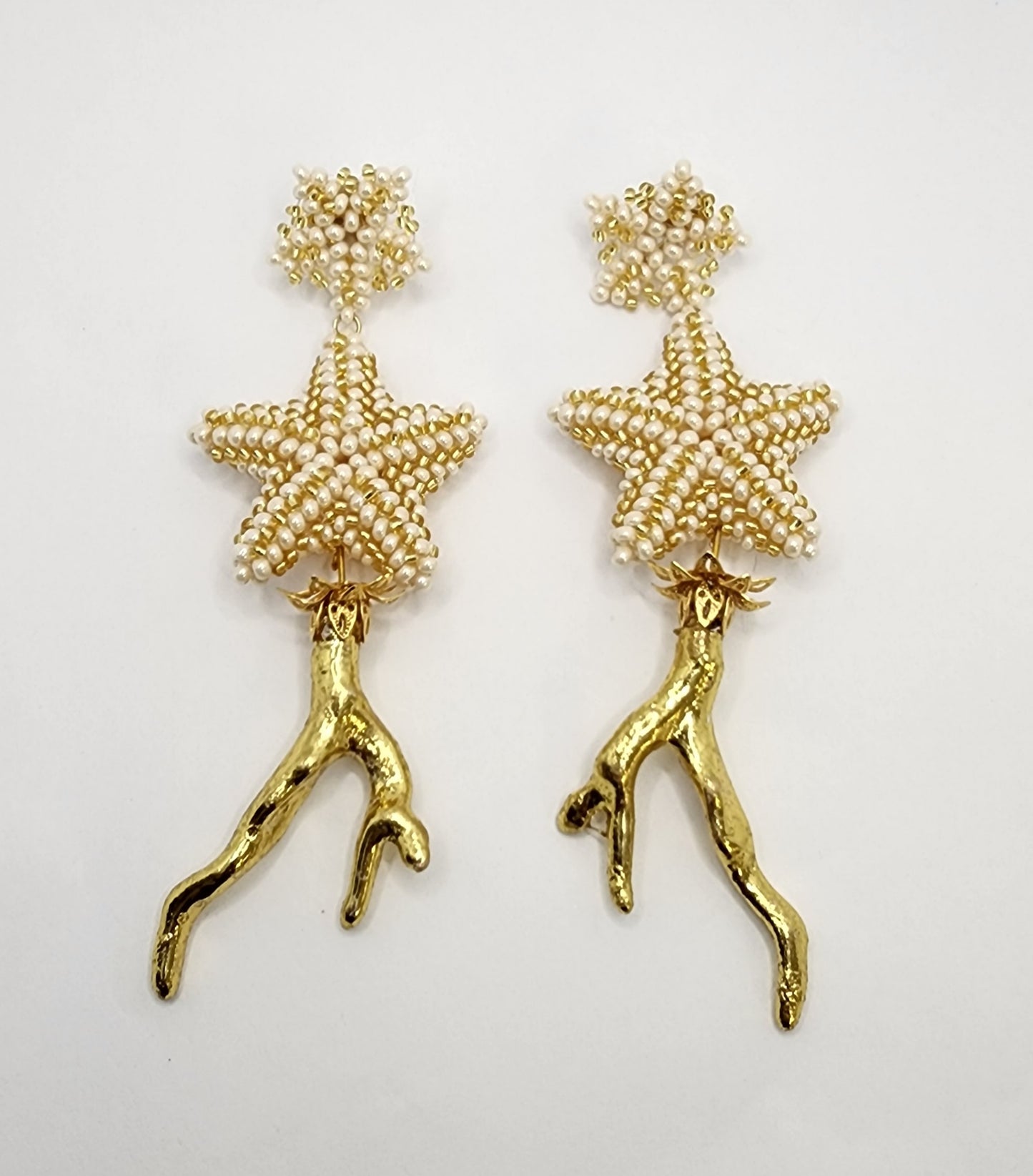 Handcrafted earrings featuring pearl-beaded stars and gold branch-like accents, combining elegance and unique organic design.