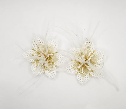 Handcrafted floral earrings with intricate white and gold beadwork, accented by delicate feathers.