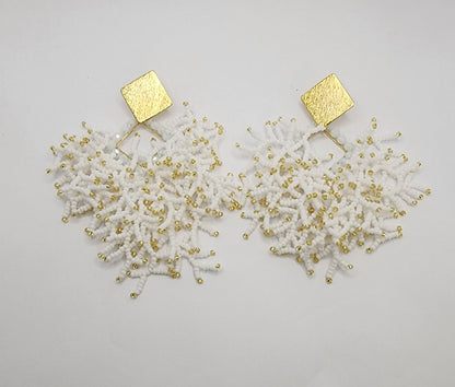 Handcrafted earrings with textured gold square tops and cascading white and gold beadwork, inspired by organic coral designs for a bold, elegant look.