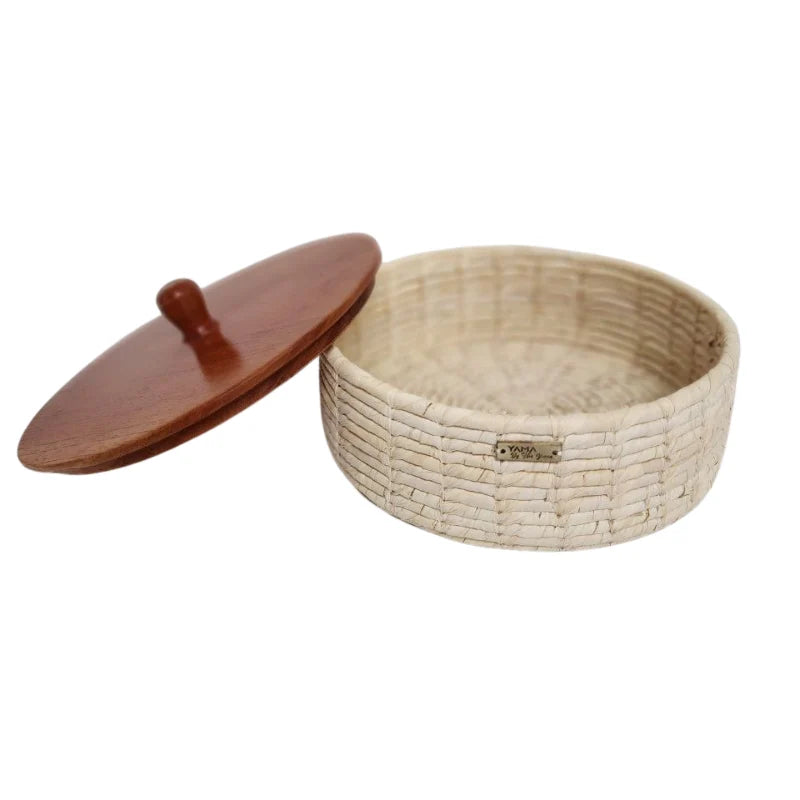 Our artisanal vegetable fiber basket with wooden accents is a stunning blend of natural beauty and timeless craftsmanship. Handcrafted by skilled artisans, each basket features unique wooden details that add warmth and elegance to any space.