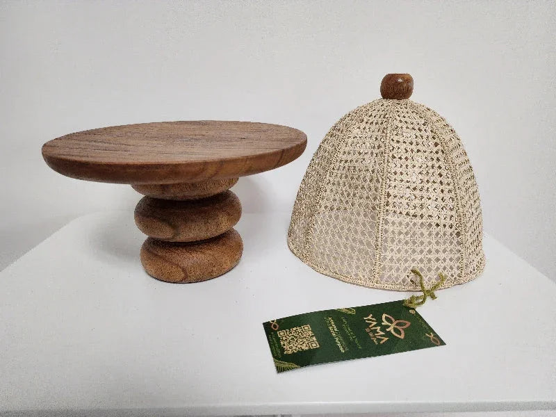 This handcrafted cake stand features a warm, caramel-toned wooden base, paired with a natural wicker cover.