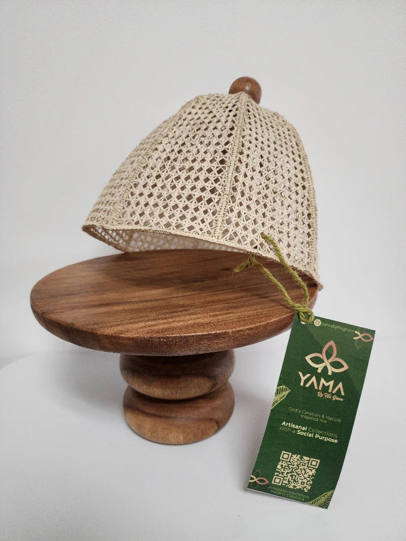 This handcrafted cake stand features a warm, caramel-toned wooden base, paired with a natural wicker cover.