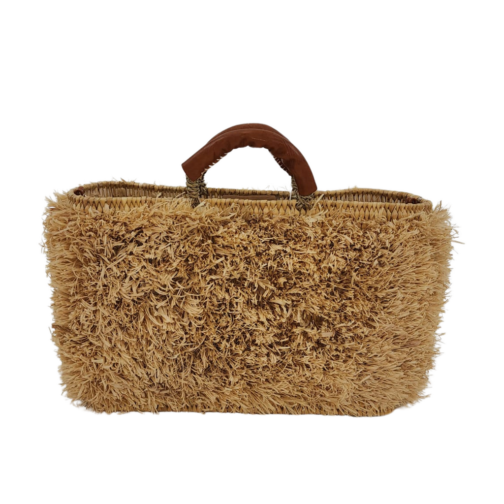 Handcrafted Iraka Leather Beach Bag with textured palm fiber body and leather-wrapped handles on white background