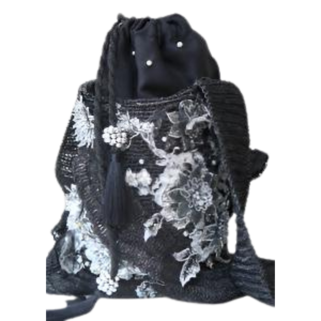 Handcrafted black shoulder bag with white floral embroidery and tassel details, displayed on a white background.