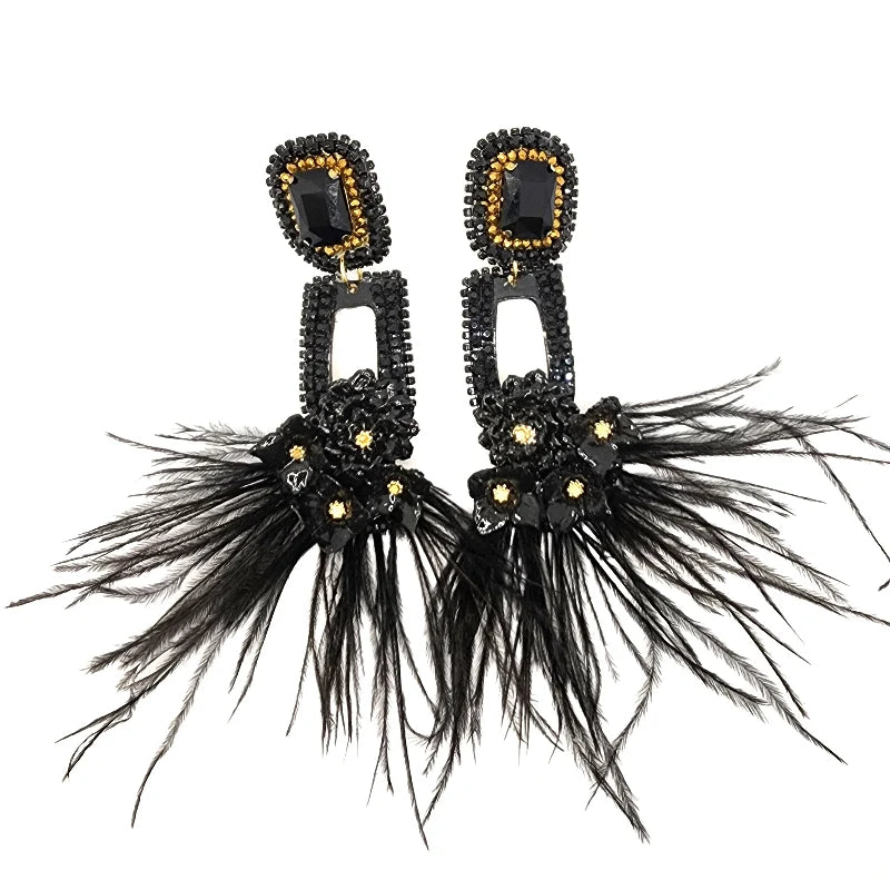 These handcrafted black earrings are made from totumo and banana fiber, adorned with flowers, feathers, and jewelry accents. They offer a unique blend of natural materials and artistic flair, perfect for adding a touch of elegance and creativity to any outfit.