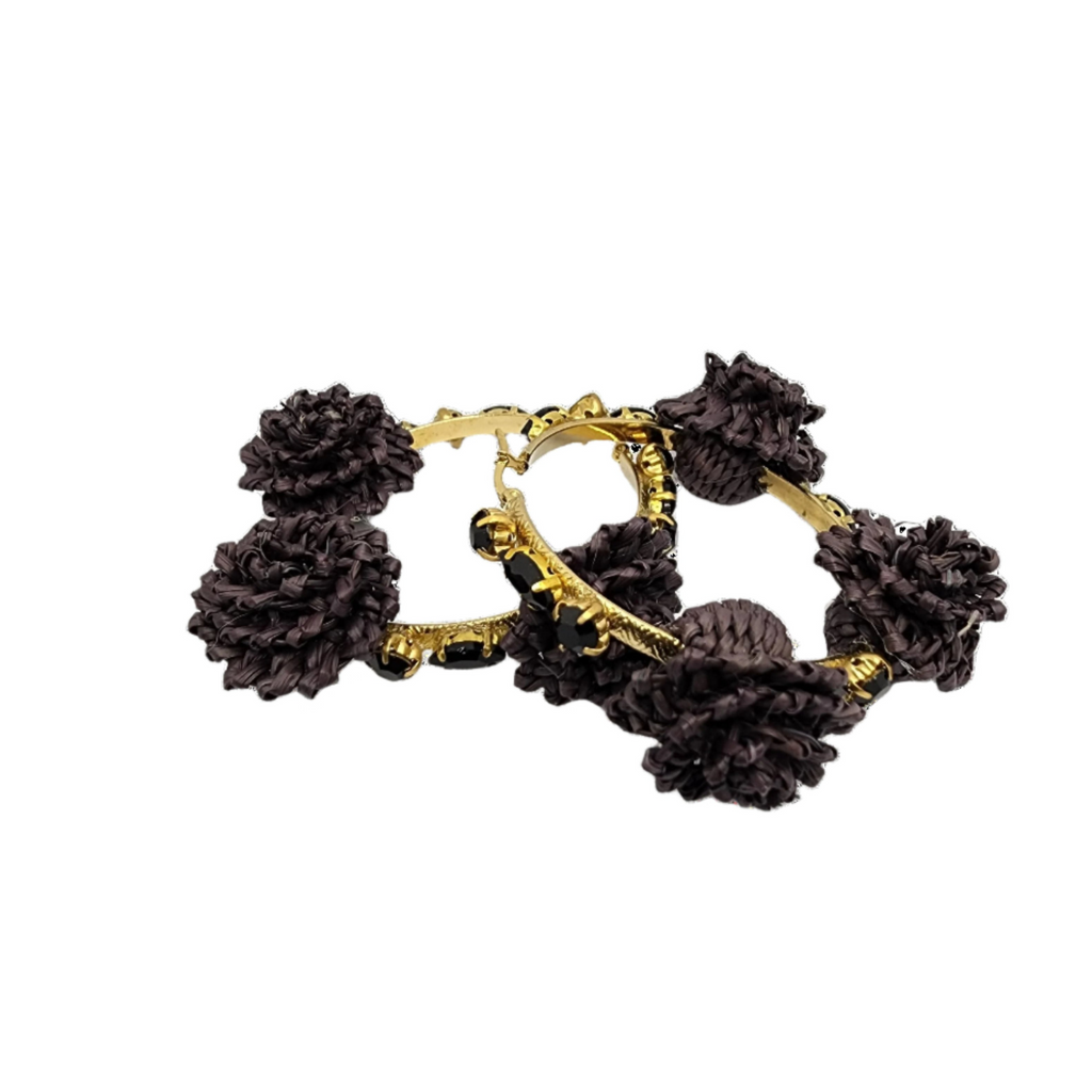 Pair of gold hoop earrings adorned with black raffia flowers and faceted black beads, showcasing handcrafted Colombian design.