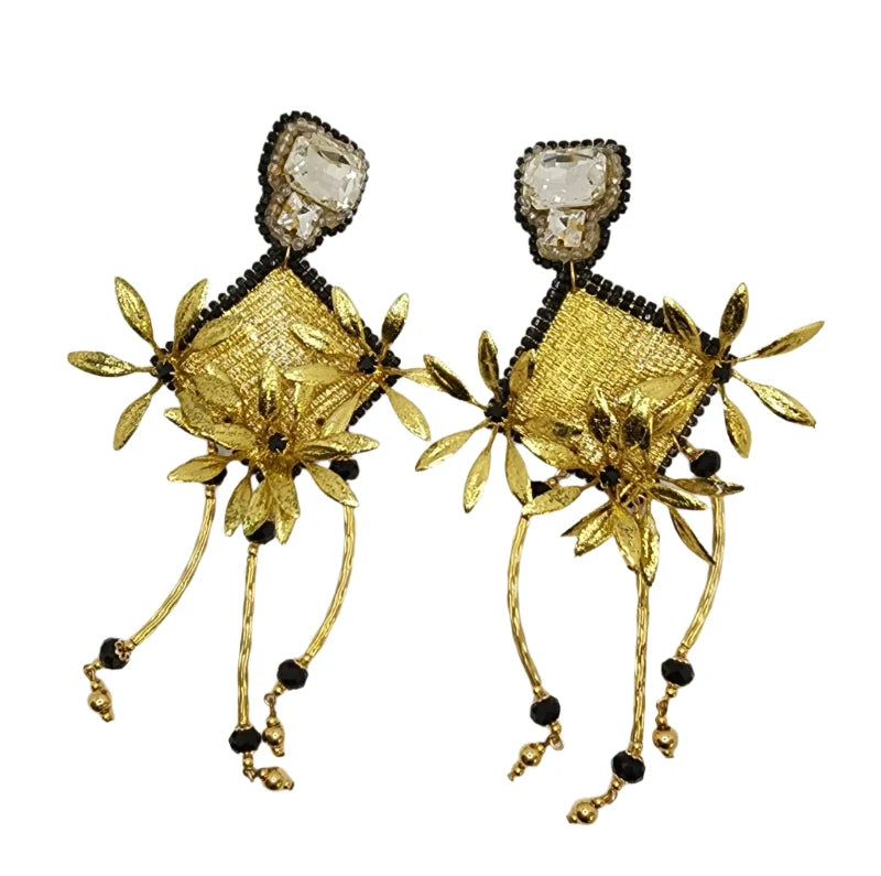 These handcrafted earrings combine a banana fiber base with hand-painted golden totumo accents