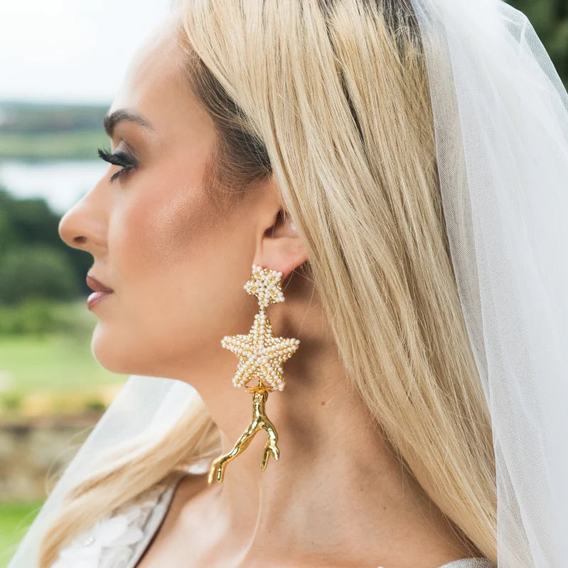 Close-up of a woman wearing bridal earrings.
