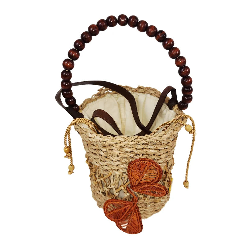 Bucket Flower Bag with orange woven flower accent, wooden beaded handle, and drawstring closure on white background