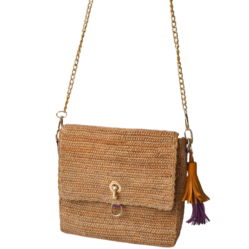 Handcrafted tan crossbody bag with gold hardware and dual tassel charm
