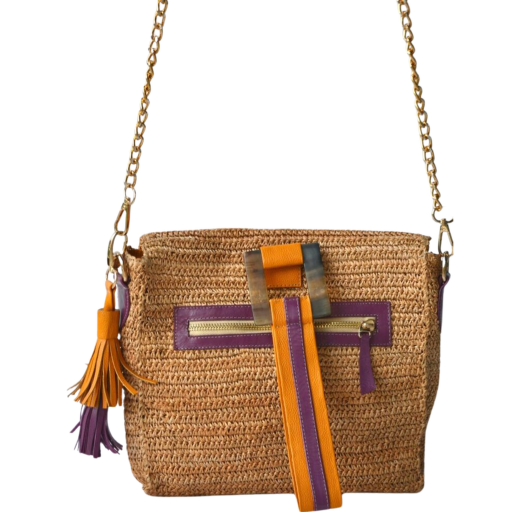 Back view of tan crossbody bag featuring purple leather zipper and striped decorative strap