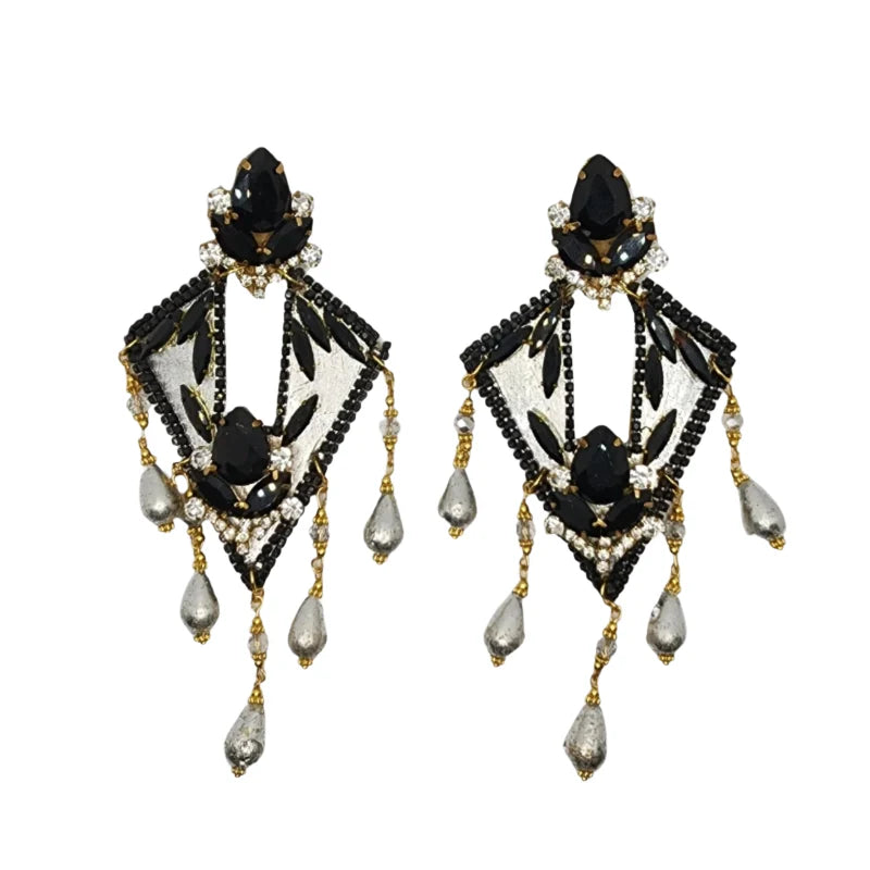 These earrings are crafted from totumo in a rhombus shape, painted silver with fine black and silver gemstones.