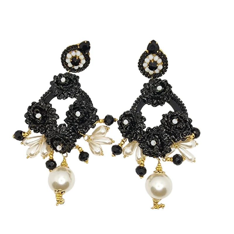 This exclusive Black &amp; White fine jewelry Collection is a unique Design inspired in God's Beautiful creation of day and night. Handcrafted with Banana Tree Fibers painted flowers, painted Totumo fruit, gemas, Murano stones and jewelry.