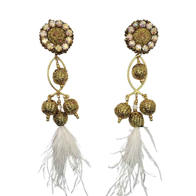 A pair of gold and white fisherman earrings with intricate beadwork and feathered tassels.