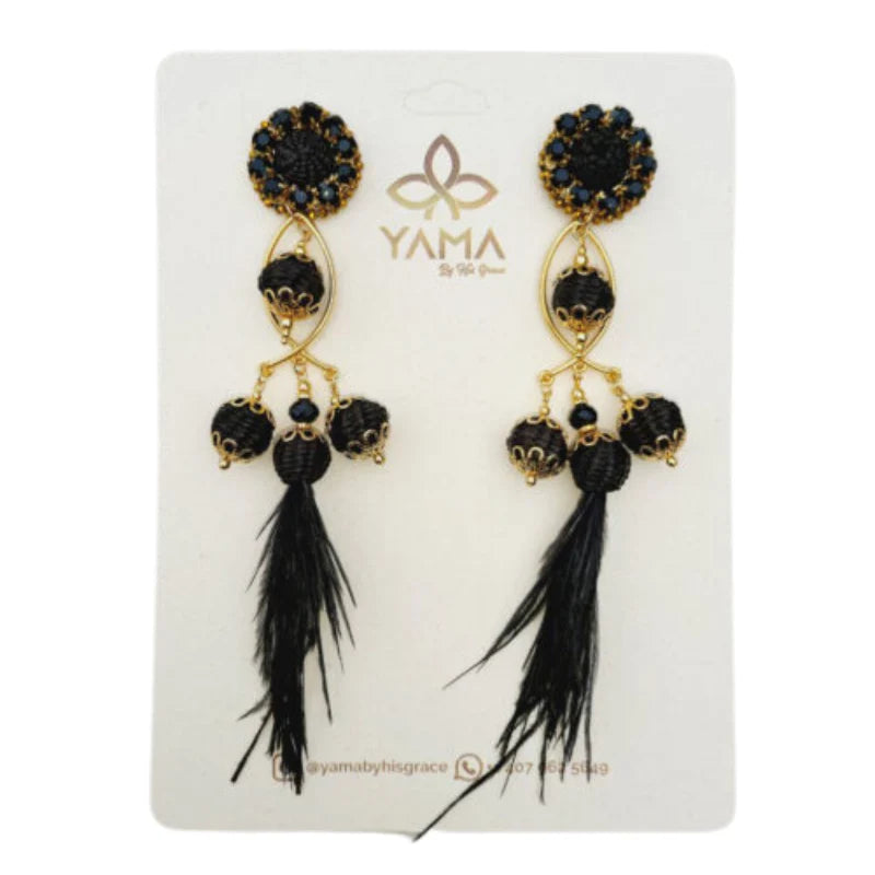 A pair of gold and white fisherman earrings with intricate beadwork and feathered tassels.