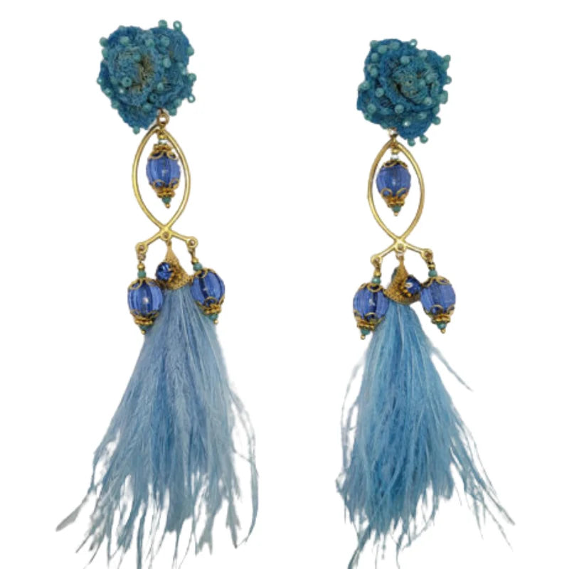 A pair of gold and purple fisherman earrings with intricate beadwork and feathered tassels.