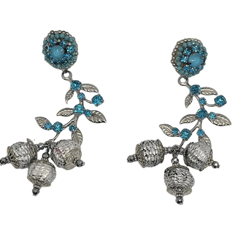 These handmade earrings feature a cute flower design with a delicate leaf accent, symbolizing the natural beauty of God’s creation. Crafted from Banana Tree Fibers, the earrings are beautifully decorated with sparkling rhinestones and a fine jewelry leaf, all in a stunning turquoise and silver colors.