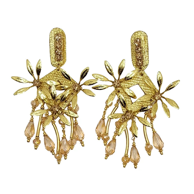 These handcrafted earrings are made from totumo in a diamond shape, featuring delicate handcrafted flowers made from banana fiber painted in gold. 