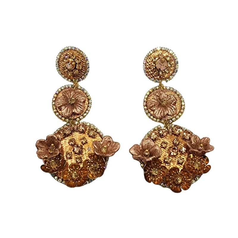 These Colombian artisan earrings feature a circular cascading design, crafted from banana fiber and a totumo base, delicately painted in rose gold.