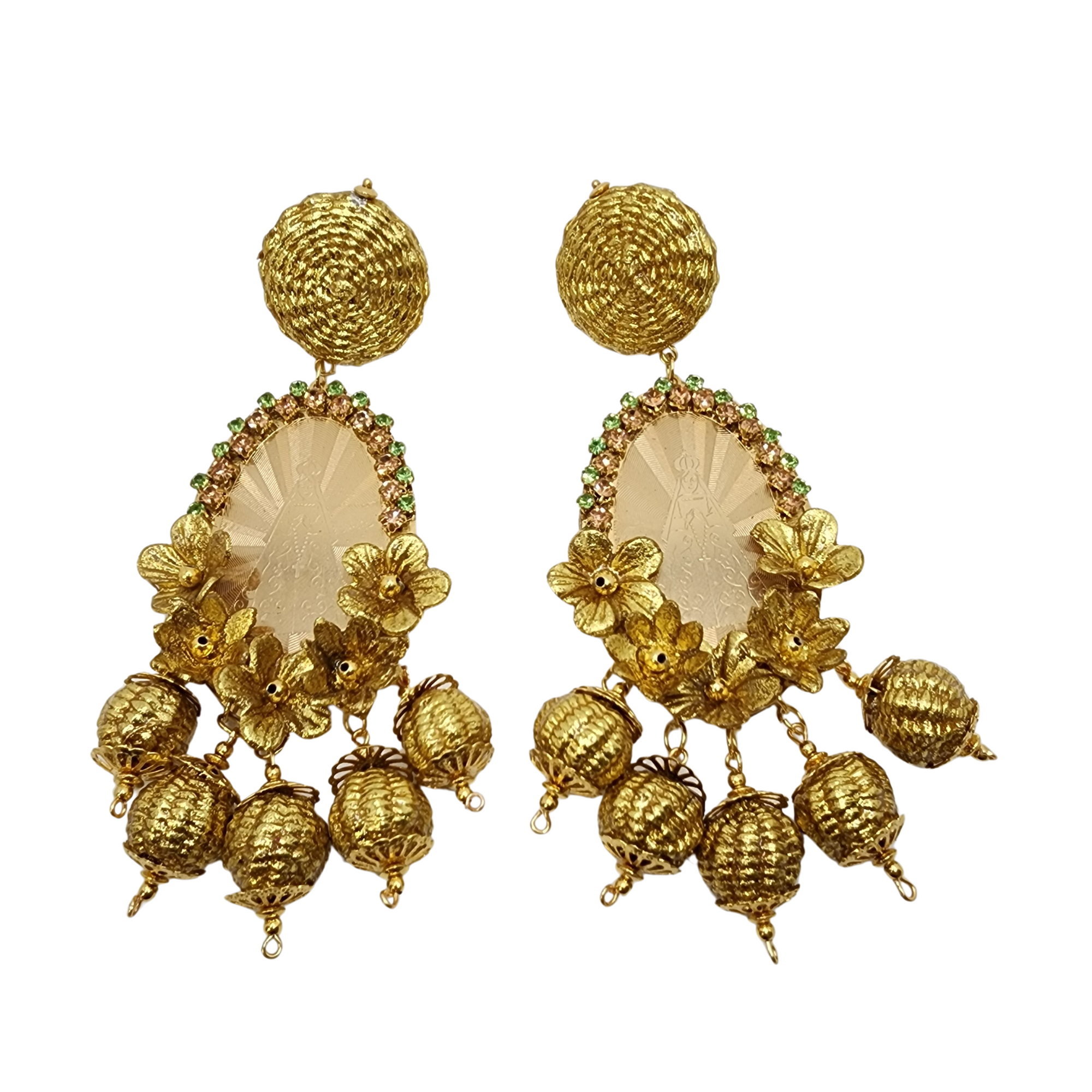 Pair of ornate gold earrings featuring a religious engraving, floral embellishments, and round dangling elements with green crystal accents.