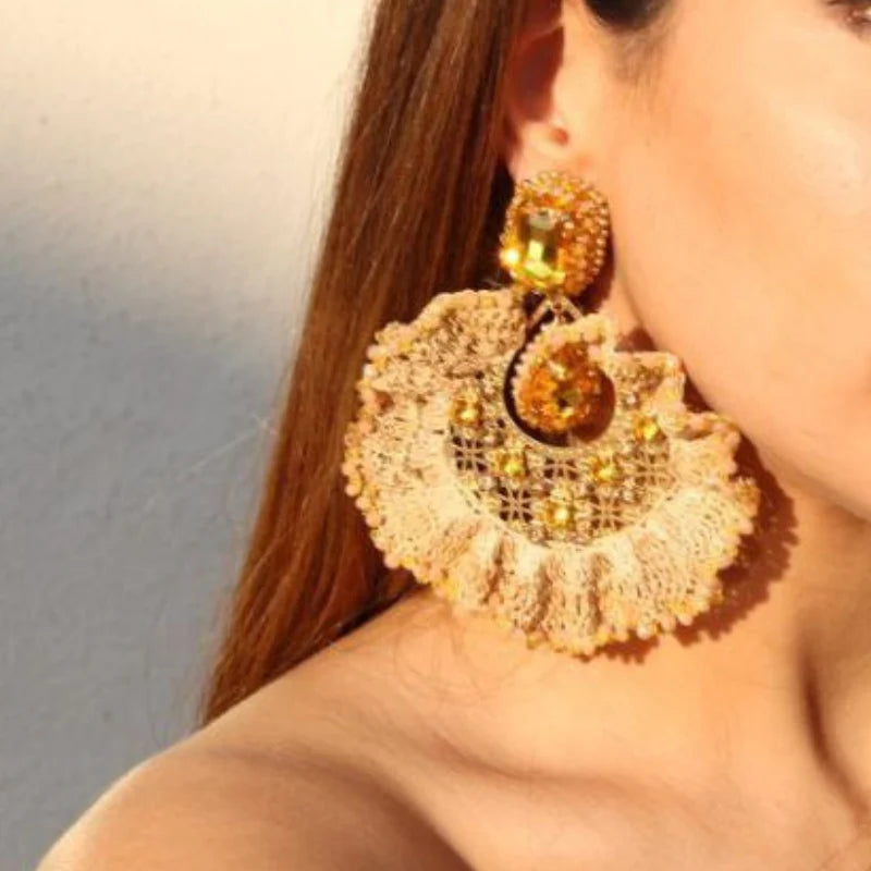 These exquisite earrings are shaped like a ruffled leaf, beautifully decorated with vibrant Murano stones at its base and fine jewelry accents in the center. Handmade with Banana Tree Fibers, these earrings exude elegance with their sparkling, shiny appearance. 