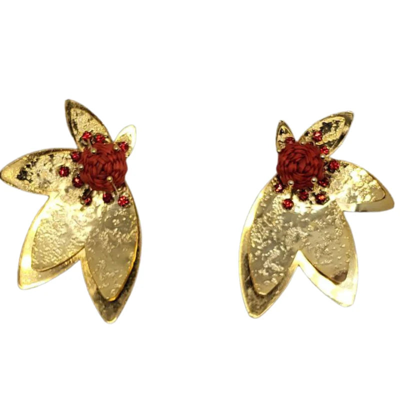 The Golden Red Bloom Earrings feature a striking combination of golden petal-shaped panels and a central woven red fiber flower. Adorned with delicate red crystals, these earrings exude sophistication and elegance, creating a bold statement piece perfect for special occasions.