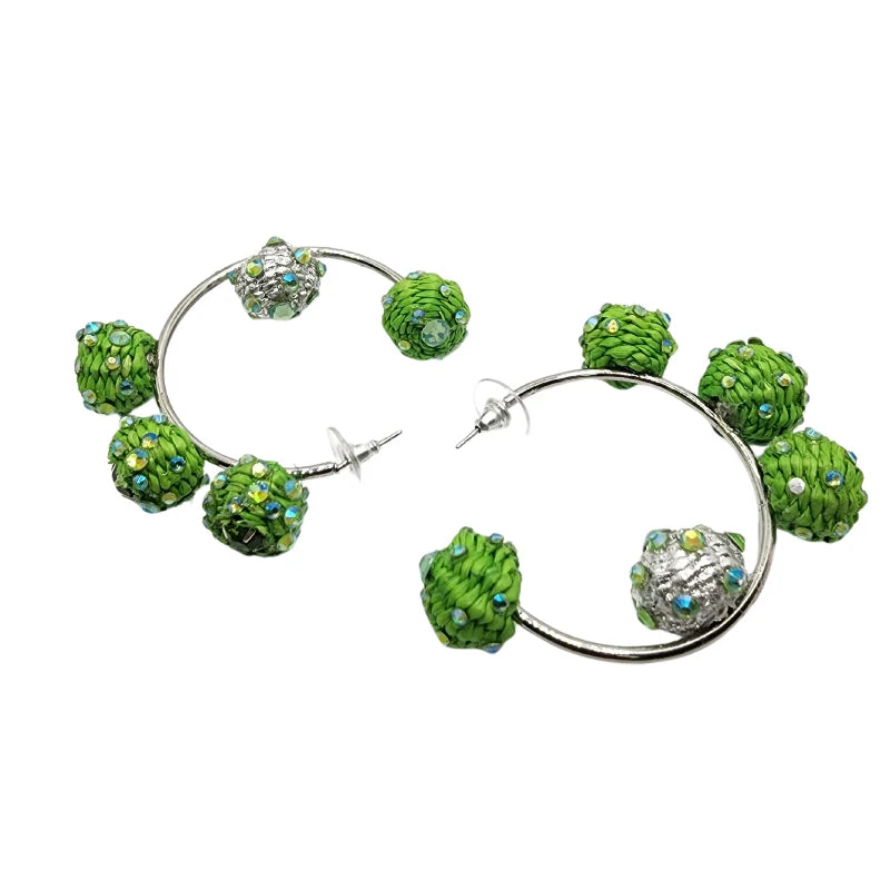 These large bead earrings dangle elegantly in a circular shape, beautifully combined with fine jewelry accents. Handmade with natural Banana Tree Fibers, they are stunningly decorated with carefully selected beads.