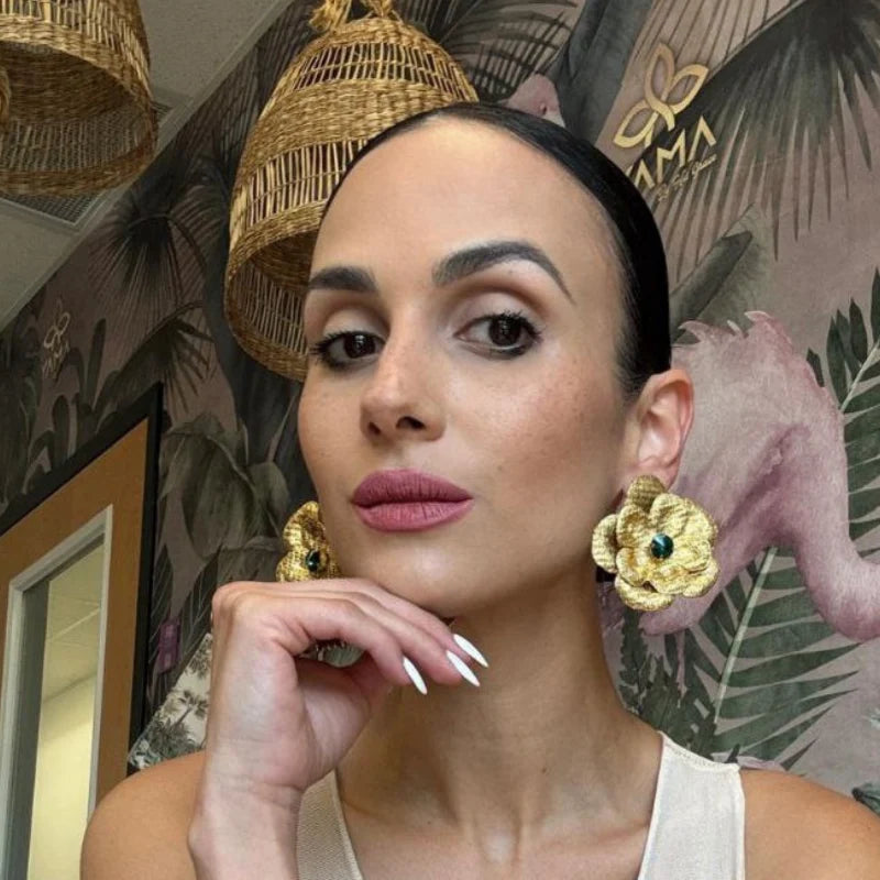 woman wearing a golden flawer earrings
