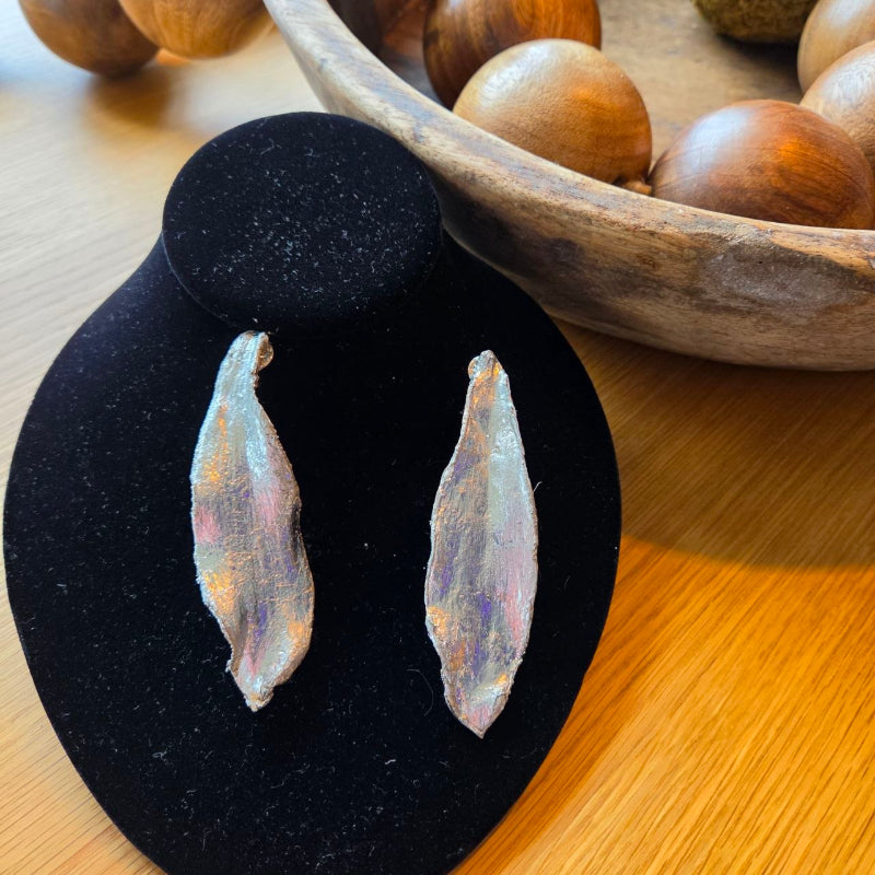 The luxury of nature, captured in a designer statement piece.
Elevate your presence with these extra-long leaf earrings—a statement design crafted for the confident woman who appreciates the true value of artisanal jewelry. Inspired by the fluidity and commanding silhouette of nature, each pair features hand-chiseled detailing, creating a unique texture designed to catch the light and radiate an infinite shine from every angle.
