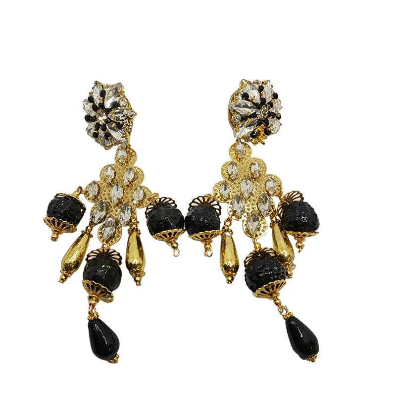 These earrings feature transparent and black gemstones at the top, cascading down with golden sheets decorated with touches of transparent gemstones.