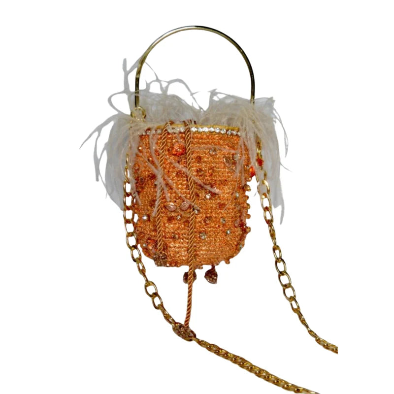 This rose gold minaudière bag is a stylish accessory for storing small essentials like makeup, lipstick, or your phone. Made with gold-plated banana fibers and Murano stones, it has a metal handle and a Murano-decorated tail. Great for parties, dinners, and special events.