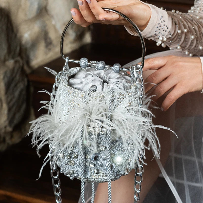 The Minaudière Silver &amp; Feather Bag emerged in the 1930s as a stylish jewelry piece and iconic fashion accessory. Perfectly sized to store a compact, lipstick, or cellphone, this modern take is ideal for accessorizing at parties, dinners, or special events.