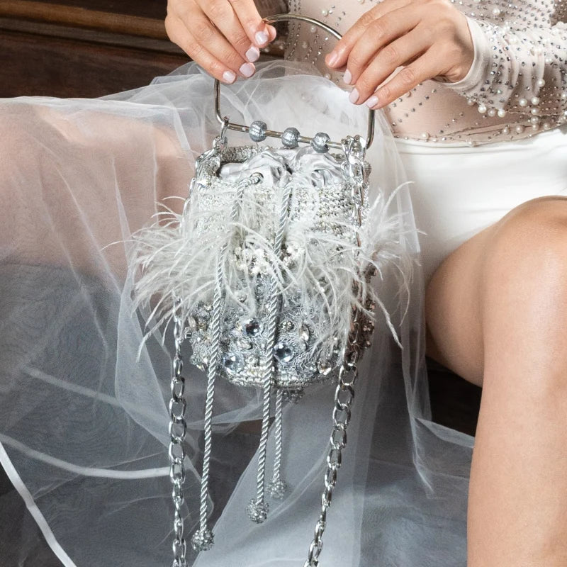 The Minaudière Silver &amp; Feather Bag emerged in the 1930s as a stylish jewelry piece and iconic fashion accessory. Perfectly sized to store a compact, lipstick, or cellphone, this modern take is ideal for accessorizing at parties, dinners, or special events.
