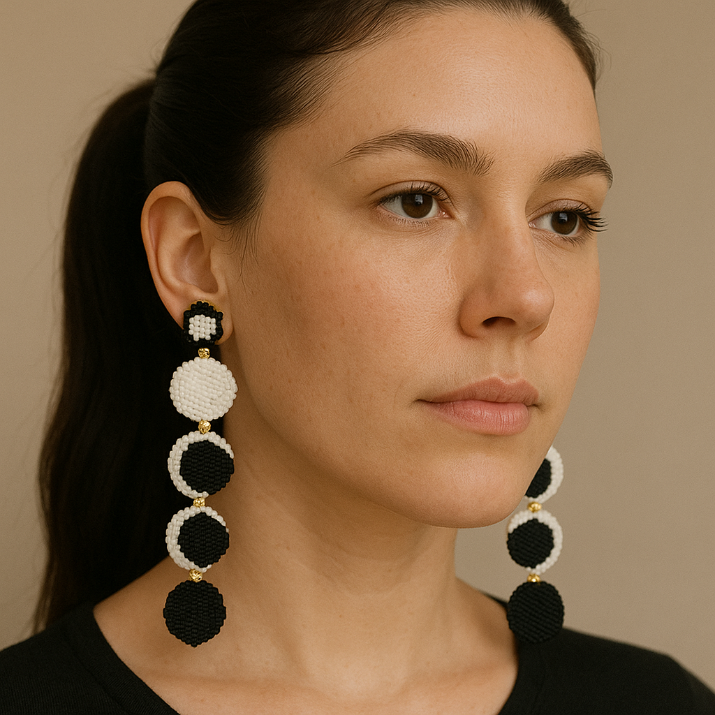 Model wearing Miyuki Circle Fall Earrings with cascading round black and white beaded circles and subtle gold detail handcrafted with precision