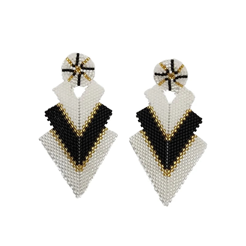 These glass bead earrings in white, black, and gold feature a unique geometric structure with a round top and a flowing triangle-shaped waterfall design