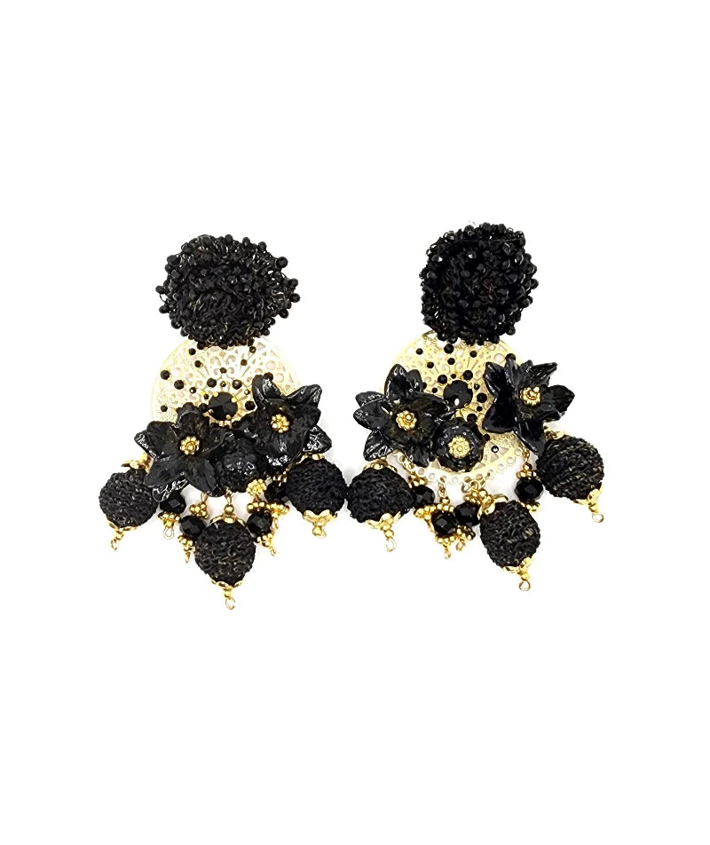 Pair of handcrafted black and gold earrings with floral details and textured dangling beads.