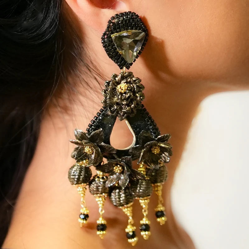 Close-up of an ornate earring with a dark gemstone and gold accents.
