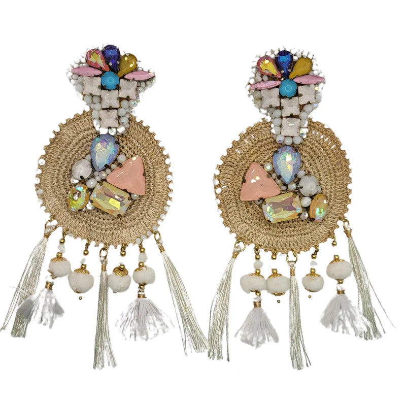This majestic sun-shaped earring is crafted from natural fibers, embroidered with small Murano beads, and combined with fine jewelry. It is further adorned with Murano stones, dangling tassels, puffy beads, and delicate feathers, showcasing a radiant design. Handmade with Banana Tree Fibers.