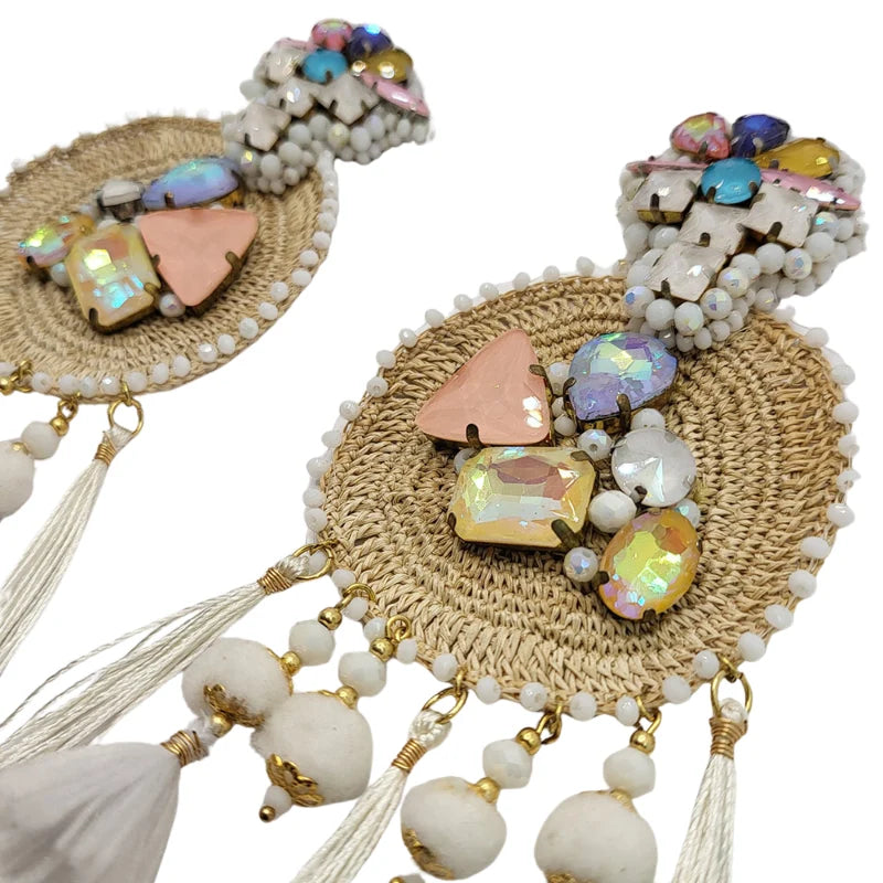 This majestic sun-shaped earring is crafted from natural fibers, embroidered with small Murano beads, and combined with fine jewelry. It is further adorned with Murano stones, dangling tassels, puffy beads, and delicate feathers, showcasing a radiant design. Handmade with Banana Tree Fibers.