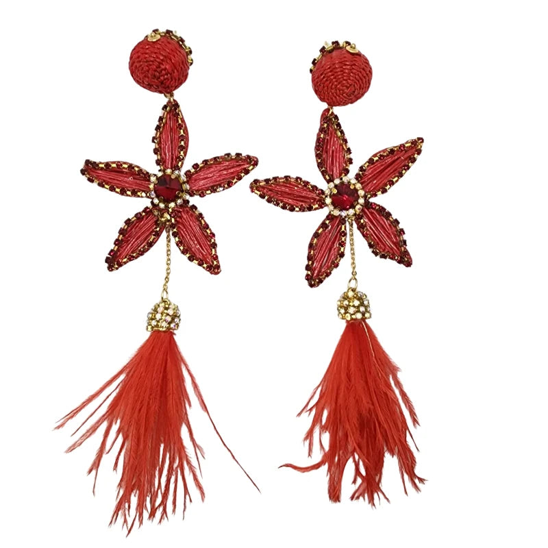 Pair of handcrafted red floral earrings with gold accents, crystal centers, and flowing red faux feathers.