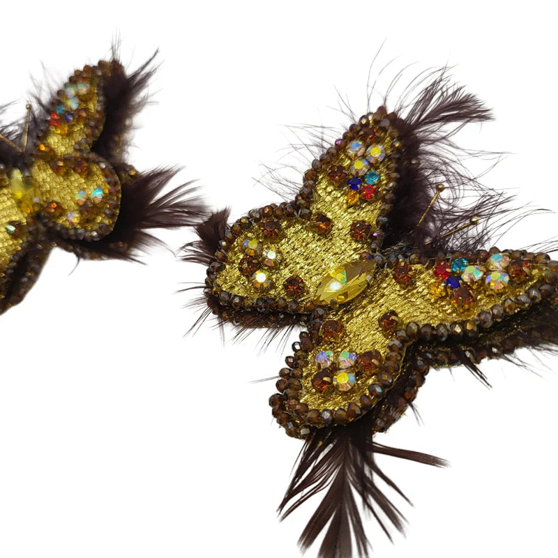 These gorgeous earrings feature a butterfly-like shape, intricately embroidered with small Murano stones, and bordered with colored Murano stones along the edges of the feathers. Symbolizing transformation, like the passage from 1st Corinthians 15:40—"I will transform myself, we could walk on water and fly like butterflies"—these earrings are crafted from Banana Tree Fibers.