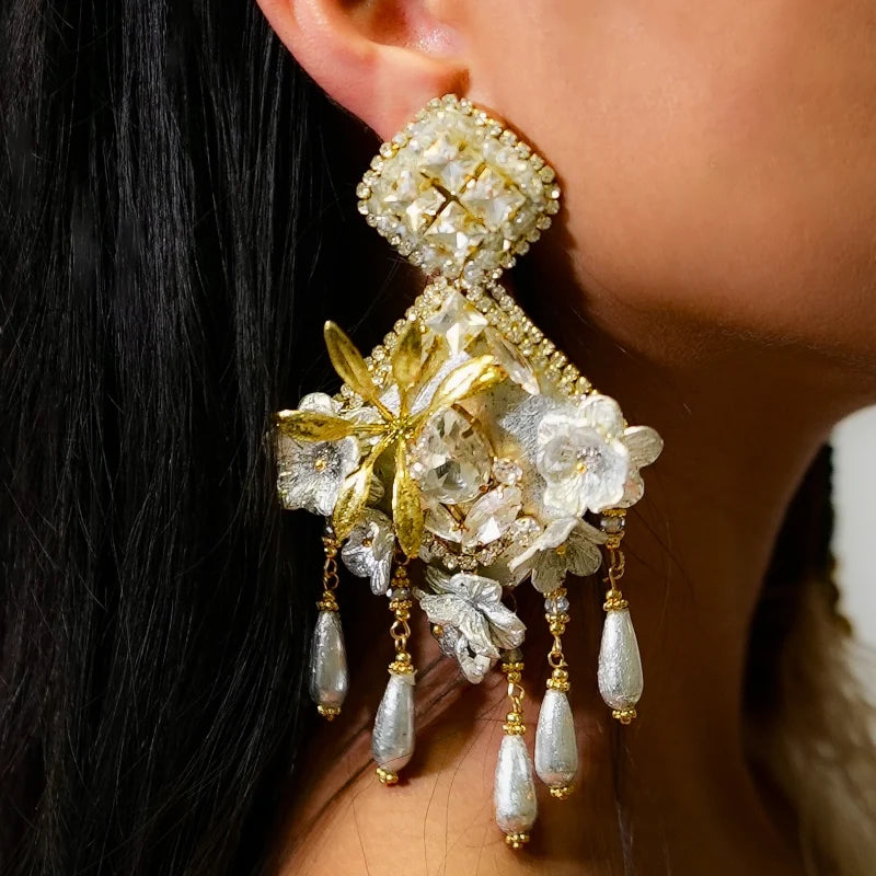 Close-up of a person wearing an ornate gold and pearl earring.