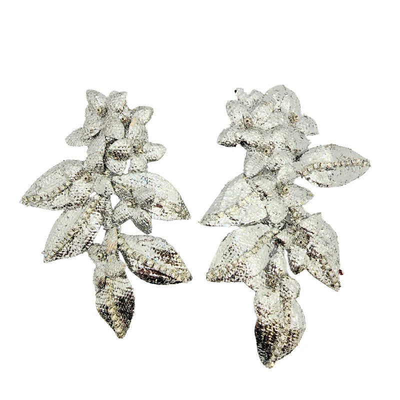 The Silver Leaf Bloom Earrings feature a stunning design with intricate leaves and floral elements, crafted in silver and adorned with sparkling accents