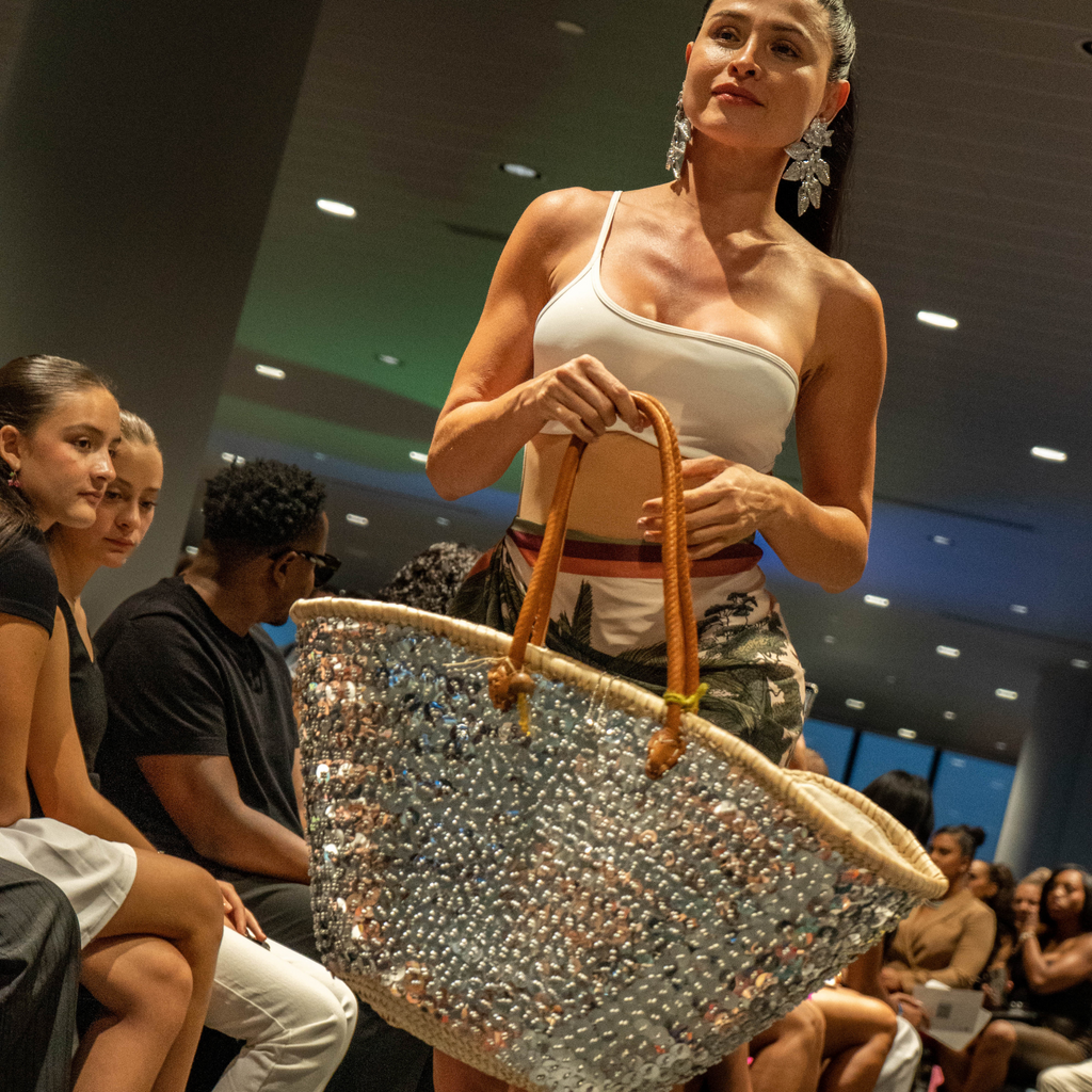 Model walking the runway with the Silver Lentejuelón Bag, showing silver sequins and bold leather handles